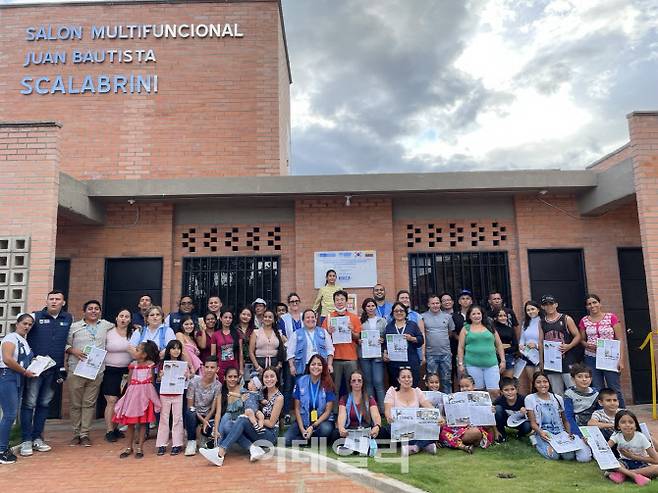 지난달 30일(현지시각) 콜롬비아 노르테데산탄데르주에서 개최된 ‘콜롬비아 내전 피해 난민 재정착 지원사업 종료식’에서 KOICA가 지원하여 건축한 스카나브리니(Scanabrini) 마을 주민센터 앞에서 거주민들과 단체 사진을 찍고 있다.(사진=코이카 제공)