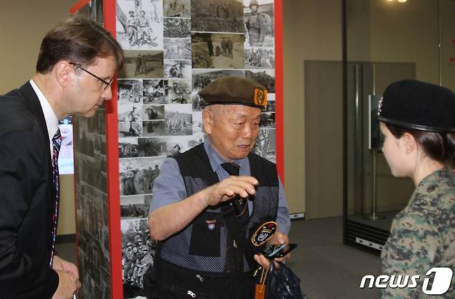 유엔평화기념관 ‘네덜란드 유엔참전용사 특별 사진전’에서 6·25전쟁에 카투사로 참전했던 최병수씨(가운데)와 켐벨 에이시아(오른쪽)가 이야기를 나누고 있다.(유엔평화기념관 제공) © 뉴스1