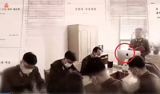 북한이 지난 4월 25일 진행한 열병식과 관련해 제작한 기록영화 속에 애플컴퓨터가 등장했다. 열병식 관계자들이 사무실에서 회의를 진행하고 있다. 북한은 이 기록영화를 지난달 28일 방영했다. [조선중앙TV촬영]