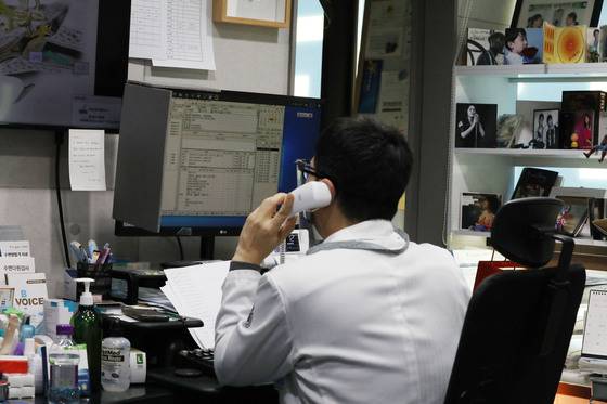 (서울=뉴스1) 임세영 기자 = 17일 서울 중구 보아스 이비인후과병원에서 오재국 원장이 어제 코로나19 확진 판정을 받은 환자에게 전화 걸어 비대면 진료를 보고 있다. 정부는 지난 10일부터 코로나19 확진자 중 ‘집중관리군’ 위주로 유선 모니터링을 진행하고, 일반관리군은 동네 병·의원 비대면 진료를 받는 새 재택치료 체계에 돌입했다. 2022.2.17/뉴스1