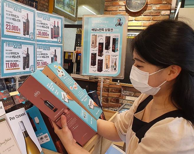 이마트24가 배달의민족과 이달의 와인 행사를 전개한다. 사진은 이마트24 매장에서 와인을 살펴보는 소비자의 모습./사진제공=이마트24