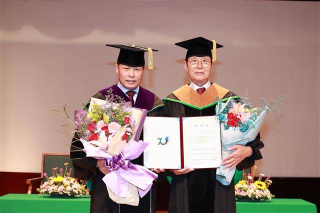 박치영(오른쪽) 모아그룹 회장이 지난 29일 전남대 용봉홀에서 열린 학위수여식에서 명예 경영학 박사 학위를 받은 뒤 기념사진을 찍고 있다.전남대 제공