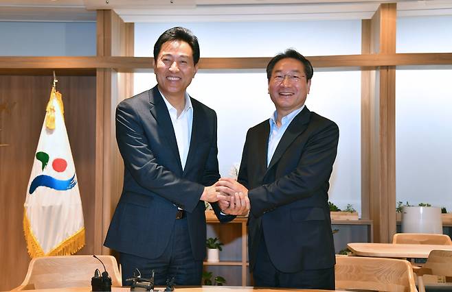 오세훈 서울시장(왼쪽)과 유정복 인천시장이 27일 서울시청에서 두 손을 맞잡고 앞으로 시민행복을 위해 협치하기로 했다. 인천시장 당선인 인수위 제공.