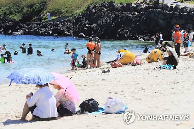 제주 해수욕장 일제 개장 (제주=연합뉴스) 박지호 기자 = 제주도 내 해수욕장 개장 첫날인 1일 오후 제주시 조천읍 함덕해수욕장을 찾은 피서객이 물놀이하고 있다. 2022.7.1 jihopark@yna.co.kr