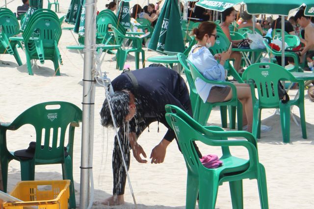 제주지역 해수욕장이 개장한 뒤 첫 주말을 맞은 2일 오후 제주 함덕해수욕장에서 한 피서객이 머리를 적시며 더위를 식히고 있다. 뉴시스