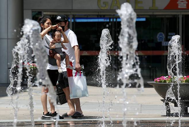 전국 대부분 지역에 폭염 특보가 발효된 1일 광주 서구 김대중컨벤션센터에서 한 가족이 시원하게 내뿜는 바닥분수 물줄기 바라보며 더위를 식히고 있다. [연합]