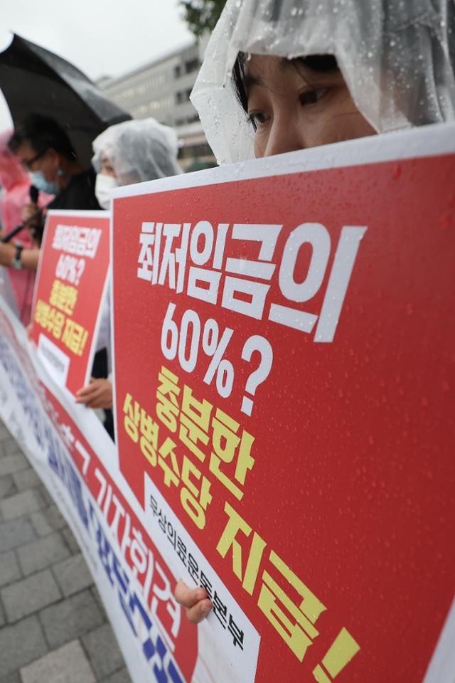 무상의료운동본부, 전국민주노동조합총연맹 등 시민사회단체 관계자들이 지난달 30일 서울 용산구 전쟁기념관 앞에서 열린 상병수당 보장성 확대 촉구 기자회견에서 손팻말을 들고 있다. 연합뉴스