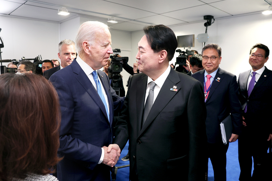 President Yoon Suk-yeol, right, shakes hands with U.S. President Joe Biden ahead of a trilateral summit with Japanese Prime Minister Fumio Kishida on the sidelines of a NATO gathering at the IFEMA Convention Center in Madrid Wednesday afternoon. [JOINT PRESS CORPS]