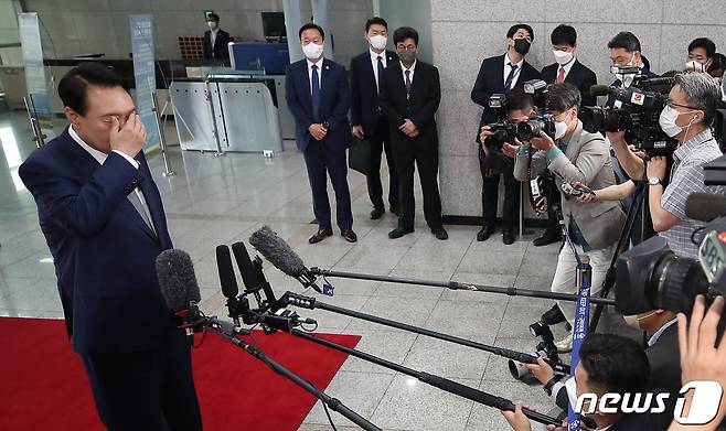 윤석열 대통령이 24일 오전 용산 대통령실 청사에서 열린 출근길 도어스테핑 도중 촬영 조명에 눈이 부신 듯 손으로 눈을 가리고 있다. (대통령실사진기자단) 2022.6.24/뉴스1 © News1 오대일 기자