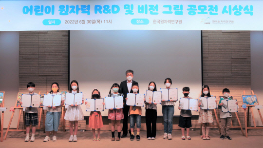 한국원자력연구원에서 지난 6월 30일 어린이 그림 공모전 시상식을 개최했다. (왼쪽에서 다섯 번째부터) 한소정 대상 수상자와 박원석 한국원자력연구원장 등이 기념사진을 찍고 있다. 사진=한국원자력연구원 제공