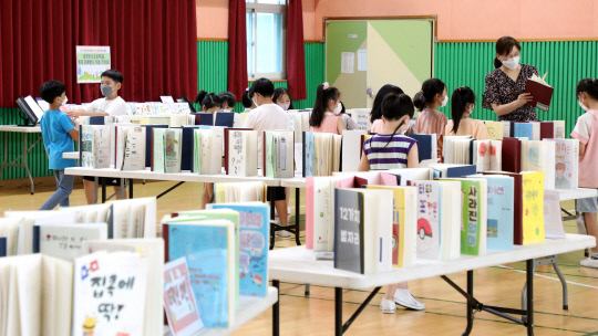 둔산초등학교 433명의 학생들이 직접 정한 주제로 책을 출판해 전시하는 '꿈을 펼치는 1인 1책 쓰기 전시회'가 4일 대전 서구 둔산초 강당에서 열려 학생들이 직접 만든 책을 읽고 있다.