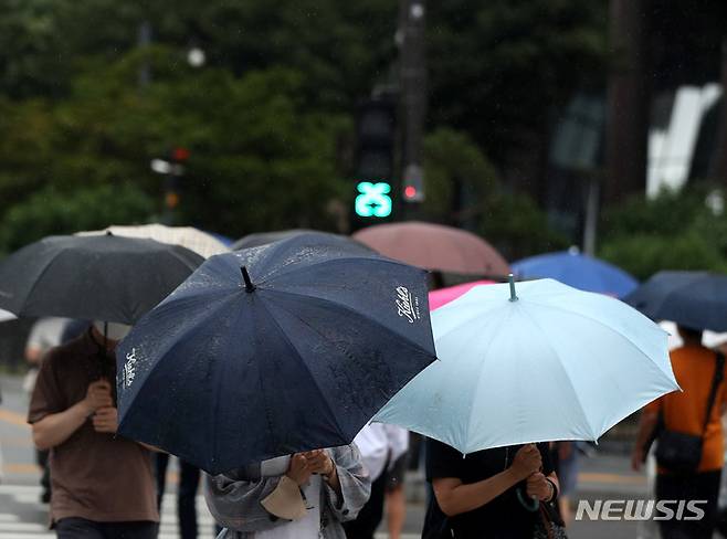 [서울=뉴시스] 추상철 기자 = 소강상태를 보이던 장맛비가 내린 지난달 29일 오후 서울 중구 세종대로 사거리에서 우산을 쓴 시민이 발걸음을 재촉하고 있다. 2022.06.29. scchoo@newsis.com