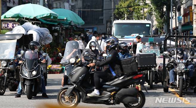 [서울=뉴시스] 추상철 기자 = 지난해 9월30일 오후 서울 종로구 동대문종합시장 인근에서  배달 종사자가  각종 물품을 배달하고 있다. 2021.09.30. scchoo@newsis.com