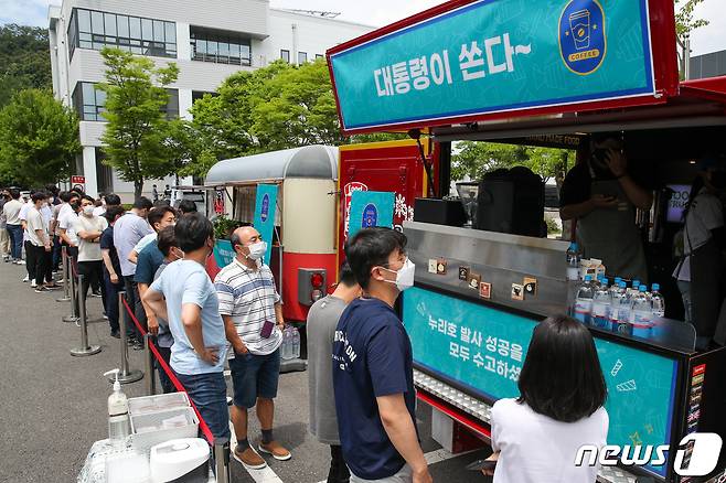 한국항공우주연구원 직원들이 6일 대전 유성구 항우연에서 음료를 주문하기 위해 줄 서 있다. 윤석열 대통령은 이날 누리호 2차 발사 성공 등을 위해 노력한 연구원들을 위해 커피와 쿠키 푸드트럭을 보냈다. 대통령실사진기자단 2022.7.6/뉴스1 © News1 안은나 기자