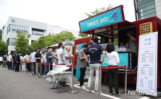 [대전=뉴시스] 전신 기자 = 한국항공우주연구원 직원들이 6일 대전 유성구 항우연에서 윤석열 대통령이 누리호 발사 성공을 축하하며 보낸 커피차에서 음료를 받고 있다. 2022.07.06. photo1006@newsis.com