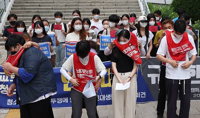 6일 오전 서울 서대문구 연세대학교 백양관 앞에서 열린 청소경비 노동자 투쟁에 연대하는 연대생 기자회견에서 노동자들이 학생들에게 조끼를 입혀주는 퍼포먼스를 하고 있다. 2022.7.6 연합뉴스