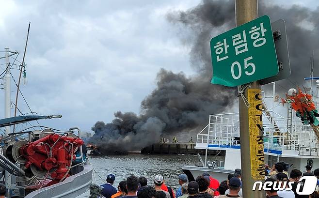 7일 오전 제주시 한림읍 한림항 안에 정박 중이던 어선 3척에서 불이나나 많은 연기가 발생하자 인근 주민들이 현장을 지켜보고 있다. 현재 이 화재로 3명이 다쳐 병원에 이송 중이다. 2022.7.7/뉴스1 © News1 오현지 기자