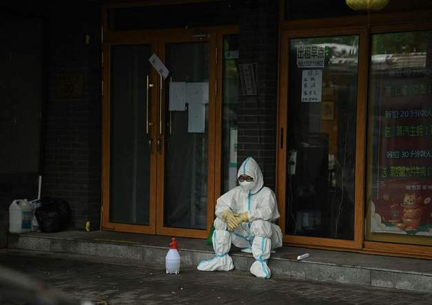 (베이징 AFP=뉴스1) 우동명 기자 = 3일 (현지시간) 코로나19가 안정세에 접어든 중국 베이징의 상점 앞에서 방역요원이 앉아서 휴식을 하고 있다.   (C) AFP=뉴스1