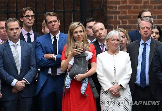 보리스 존슨 총리 발표 지켜보는 부인 캐리 여사(빨간 옷)와 측근들 (AFP=연합뉴스)