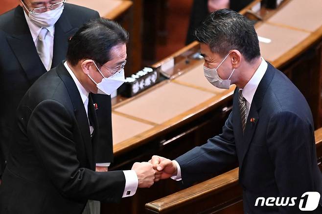 기시다 후미오 일본 총리가 6일 (현지시간) 도쿄 임시국회 중의원 본회의에 참석해 이즈미 겐타 입헌 민주당 대표와 주먹 인사를 하고 있다. © AFP=뉴스1 © News1 우동명 기자