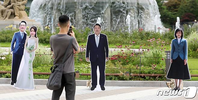 7일 오후 서울 종로구 청와대 분수대 앞에 설치된 윤석열 대통령과 김건희 여사의 등신대 앞에서 한 시민이 사진을 찍고 있다. 2022.7.7/뉴스1 © News1 김진환 기자