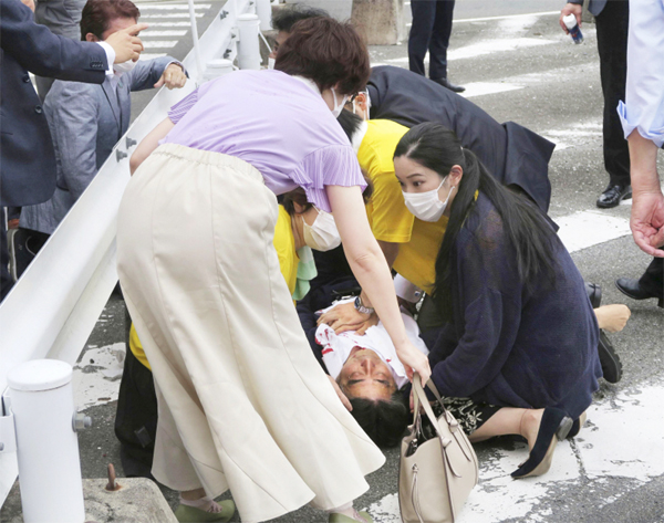 아베 신조 전 일본 총리가 8일 일본 나라시에서 참의원 선거 지원 유세 중 총격을 받은 후 쓰러져 있다. 주변 사람들이 모여 심폐소생술을 진행했지만, 심폐정지 상태에 빠졌다. 경찰은 현장에서 용의자인 야마가미 데쓰야(41)를 체포하고 범행에 사용된 총기를 압수했다. [교도 = 연합뉴스]