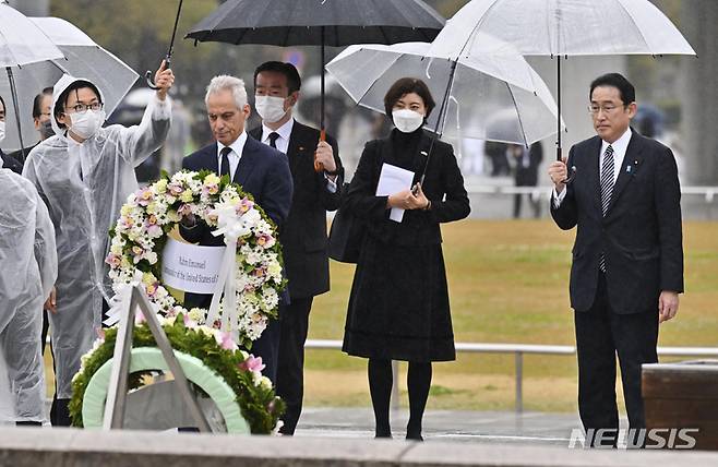 [히로시마=AP/뉴시스]지난 3월 26일 일본 히로시마의 평화기념공원에 마련된 원촉 희생자 위령비에 람 이매뉴얼 주일 미국대사(가운데)가 헌화하고 있다. 그는 기시다 후미오 일본 총리(가장 오른쪽)와 함께 히로시마를 방문했다. 2022.07.08.