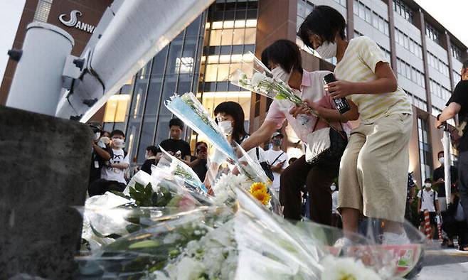 아베 신조 일본 전 총리가 총격으로 사망한 8일 오후 사고 현장인 일본 나라현 나라시 소재 야마토사이다이지역 인근 노상에서 시민들이 아베 전 총리를 추모하며 헌화를 하고 있다. 교도연합뉴스