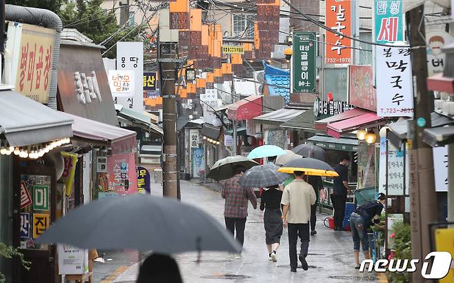 올해 1분기 코로나19 소상공인 손실보상 신청 및 지급이 시작된 30일 서울 종로구 세종마을음식문화거리에 시민들이 이동하고 있다. 중소벤처기업부는 이날부터 전용 누리집을 통해 손실보상 신속보상 대상 가운데 수령액이 확정된 63만개를 대상으로 우선 신청을 받는다. 2022.6.30/뉴스1 © News1 임세영 기자