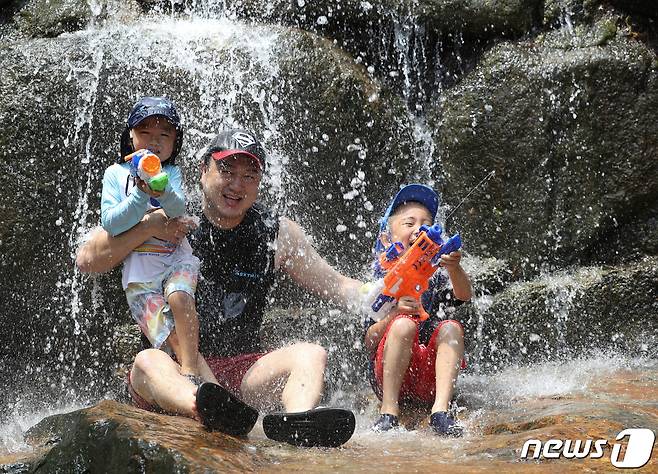 전국 대부분 지역에 폭염 특보가 내려진 10일 경기 과천시 관악산 계곡을 찾은 한 가족이 물놀이를 하며 더위를 식히고 있다. 기상청은 오늘 밤부터 장맛비가 내리며 더위가 누그러지고 장맛비가 오는 주 후반까지 이어질 것으로 예보했다. 2022.7.10/뉴스1 © News1 신웅수 기자