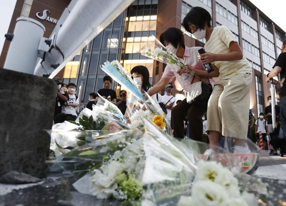 아베 신조 일본 전 총리가 총격으로 사망한 8일 오후 사고 현장인 일본 나라현 나라시 소재 야마토사이다이지역 인근 노상에서 시민들이 아베 전 총리를 추모하며 헌화를 하고 있다. 연합뉴스