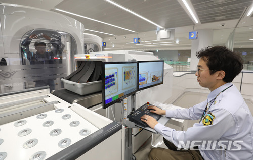 [인천공항=뉴시스]임태훈 기자 = 인천국제공항 제2여객터미널에서 대원이 원형검색기로 출국장으로 들어가는 관계를 검색하는 모습. 2022.07.08. taehoonlim@newsis.com