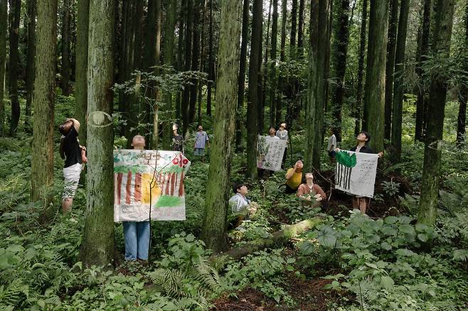 공사가 재개됐다는 소식을 듣고 찾아온 동백작은학교 학생들이 직접 만든 걸개와 함께 비자림로 숲에 섰다.