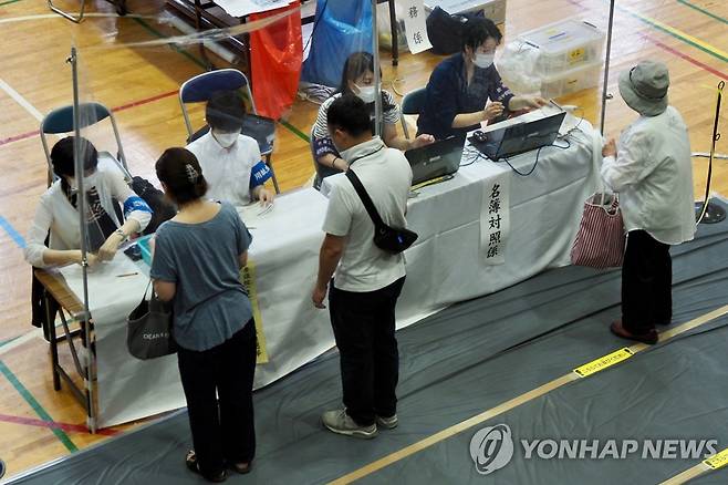 아베 피습 사망 속 치러지는 日 참의원 선거 (도쿄 AFP=연합뉴스) 사진은 지난 10일 일본 도쿄의 한 투표소에서 유권자들이 참의원(상원) 선거 투표 용지를 배부받고 있는 모습.