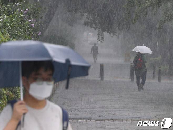 수도권에 호우주의보가 내려진 13일 서울 여의도 국회 앞에서 폭우가 내리자 한 시민이 발걸음을 재촉하고 있다. 기상청은 내일까지 중북부지역에 최대 150mm 이상, 중부지방과 호남 지역에 최대 100mm의 비가 내릴 것으로 예보했다. 2022.7.13./뉴스1 © News1 신웅수 기자