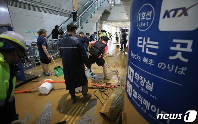 수도권 지역에 호우주의보가 내려진 13일 오후 경기 광명시 일직동 경부선(KTX) 광명역에 인근 신안산선 공사현장의 토사와 흙탕물이 지하 승강장으로 유입돼 현장 관계자들이 토사를 치우고 있다. 2022.7.13/뉴스1 © News1 김영운 기자