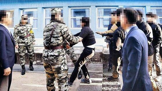 통일부는 지난 2019년 11월 판문점에서 탈북어민 2명을 북한으로 송환하던 당시 촬영한 사진을 지난 12일 공개했다. 당시 정부는 북한 선원 2명이 동료 16명을 살해하고 탈북해 귀순 의사를 밝혔으나 판문점을 통해 북한으로 추방했다. 사진은 탈북어민이 몸부림치며 북송을 거부하는 모습. &nbsp; 연합뉴스&nbsp;