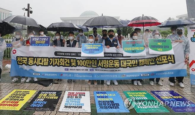 건강보험 정부지원법 개정·지원 확대 촉구 기자회견 (서울=연합뉴스) 신현우 기자 = 한국노총·민주노총·무상의료운동본부 등 시민사회단체 관계자들이 13일 오전 서울 여의도 국회 앞에서 기자회견을 열고 건강보험 정부지원법 개정과 지원 확대를 촉구하고 있다. 2022.7.13 nowwego@yna.co.kr