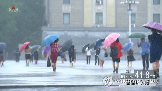 우산으로 비바람 막는 평양 시민들 (서울=연합뉴스) 조선중앙TV는 13일 대부분 지역에 100㎜ 이상의 세찬 비가 내렸다고 보도했다. 평양 시민들이 거센 비바람을 우산으로 간신히 막으며 길을 지나고 있다. [조선중앙TV 화면] 2022.7.13 
    [국내에서만 사용가능. 재배포 금지. For Use Only in the Republic of Korea. No Redistribution] nkphoto@yna.co.kr