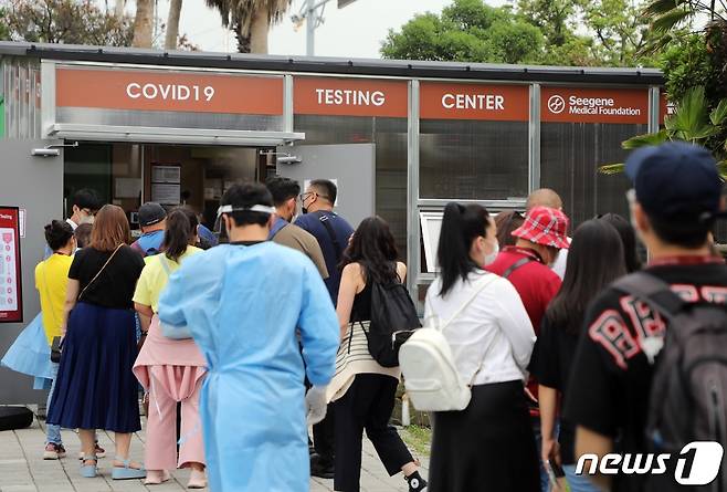 14일 오후 제주국제공항 주차장에 설치된 외국인 코로나19 검사센터에 이날 제주에 도착한 몽골인 관광객들이 줄서서 기다리고 있다. 한국공항공사 제주본부는 제주공항 국제선 재개 및 최근 코로나 확산에 대비해 이날부터 공항 내에서 코로나 검사센터를 운영하고 있다.2022.7.14/뉴스1 © News1 고동명 기자