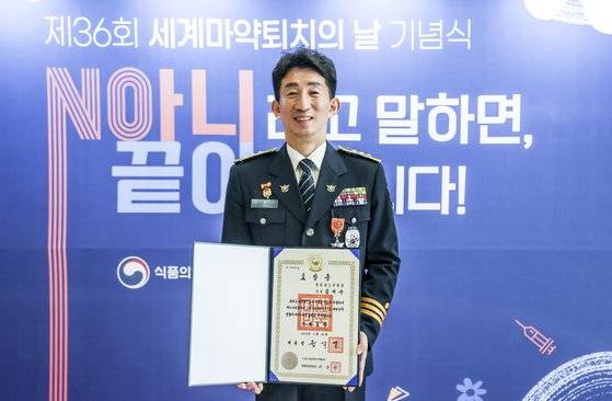 김대규 경정이 지난달 24일 서울 강남구 역삼동 삼정호텔에서 24일 열린 '제36회 세계마약퇴치의 날 기념식'에서 근정포장을 수상한 뒤 표창증을 들어 보이고 있다. 김성룡 기자