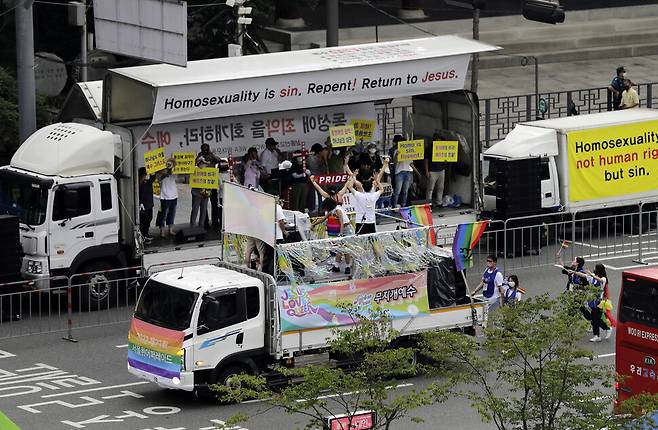 2022 서울퀴어문화축제가 열린 16일 오후 참가자들이 장대비가 내리는 가운데 서울시청 인근 을지로에서 퀴어퍼레이드를 하고 있다. 반대편에서는 기독교 신자들이 동성애 반대 시위를 하고 있다. 김명진 기자