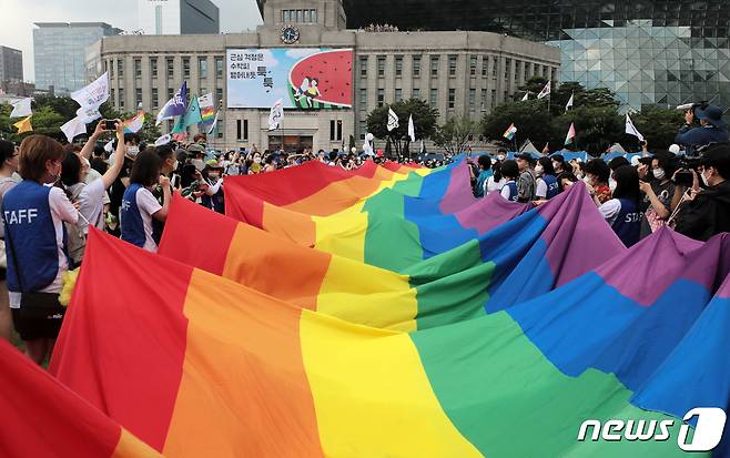 16일 서울광장에서 열린 서울퀴어문화축제를 찾은 시민들이 무지개 깃발이 펼쳐지자 환호하고 있다. 2022.7.16/뉴스1 © News1 조태형 기자