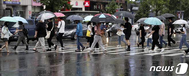 울산지역에 호우주의보가 내려진 18일 오전 울산 남구 삼산동 한 거리에서 우산을 쓴 시민들이 발걸음을 재촉하고 있다. 2022.7.18/뉴스1 © News1 윤일지 기자