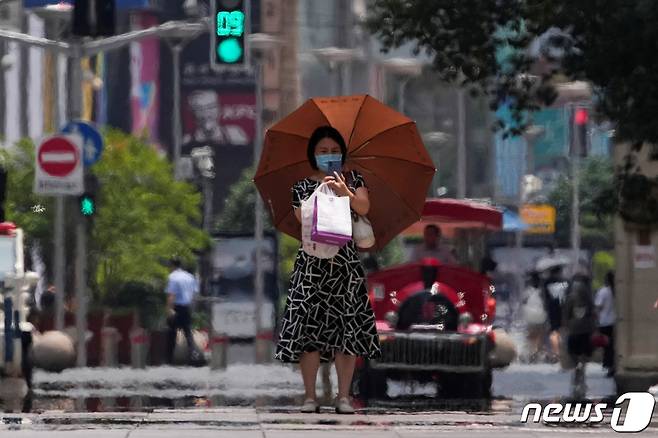 중국 상하이에서 여성 한 명이 길거리를 거닐고 있다. © 로이터=뉴스1 © News1 정윤영 기자