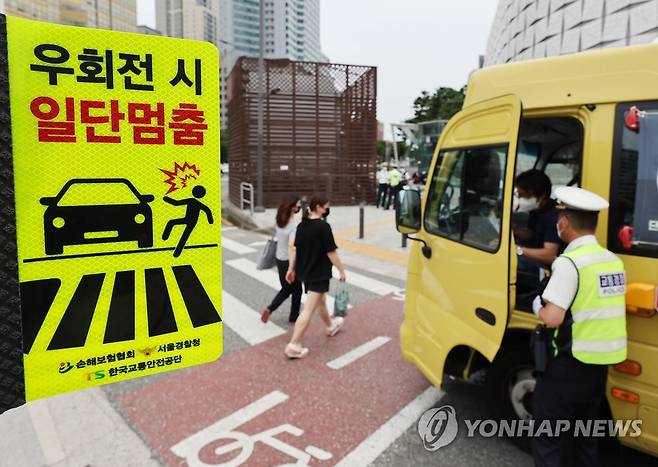 '횡단보도 보행자 보호' 도로교통법 시행 (서울=연합뉴스) 임헌정 기자 = '횡단보도 보행자 보호'를 골자로 하는 개정 도로교통법 시행 첫날인 12일 서울 송파구 잠실역 교차로에서 송파경찰서 경찰관들이 계도 활동을 하고 있다. 2022.7.12 kane@yna.co.kr