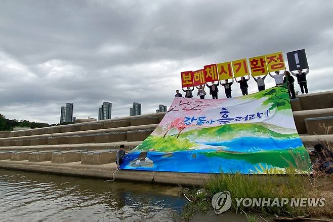 지난달 7일 세종시 금강 세종보에서 환경단체 활동가들이 금강·영산강 보 처리방안 승계와 이행을 윤석열 정부에 촉구하는 행위극을 하고 있다. [영산강재자연화시민행동 제공. 재판매 및 DB 금지]