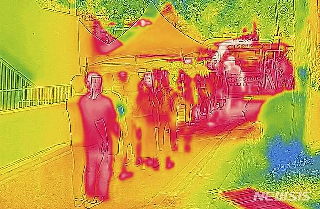 [서울=뉴시스] 정병혁 기자 = 더운 날씨가 이어진 19일 서울 강서구보건소 선별진료소를 찾은 시민들이 코로나19 검사를 받기 위해 줄 서 있다. 열화상 카메라로 촬영한 사진은 온도가 높을수록 붉은색, 낮을수록 푸른색을 나타낸다. 2022.07.19. jhope@newsis.com