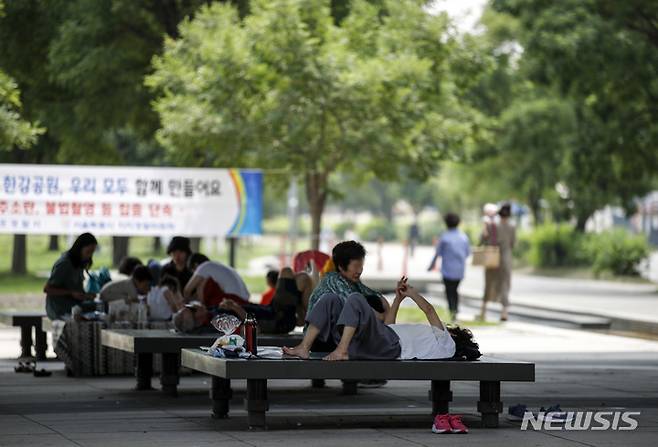 [서울=뉴시스] 정병혁 기자 = 더운 날씨가 이어진 19일 오전 서울 영등포구 여의도한강공원을 찾은 시민들이 마포대교 아래에서 더위를 식히고 있다. 2022.07.19. jhope@newsis.com