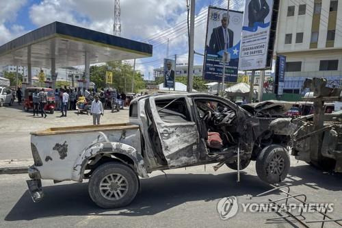 지난 5월 소말리아 수도 모가디슈에서 자살폭탄 공격에 부서진 차량의 견인 모습. [AP 연합뉴스 자료사진. 재판매 및 DB 금지]